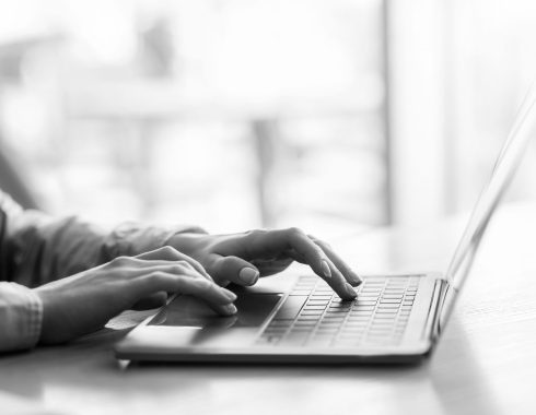 Female hands typing on laptop over blurred background